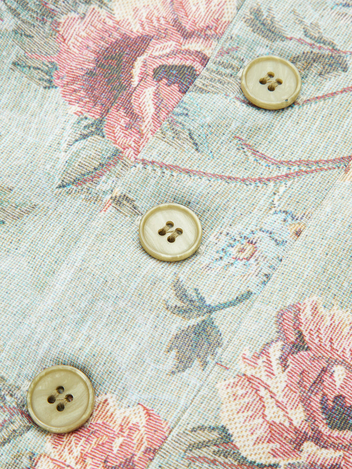 Close-up of cream four-hole buttons on the rose tapestry front of a stand collar jacket