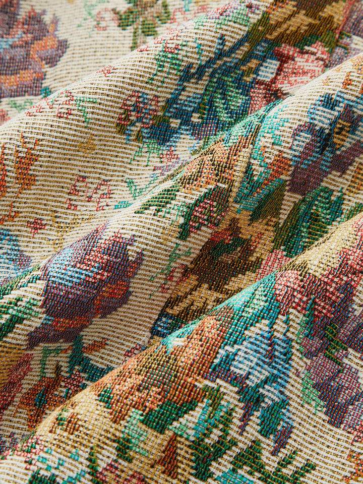 Macro of the woven floral tapestry fabric in sage, coral and cream tones
