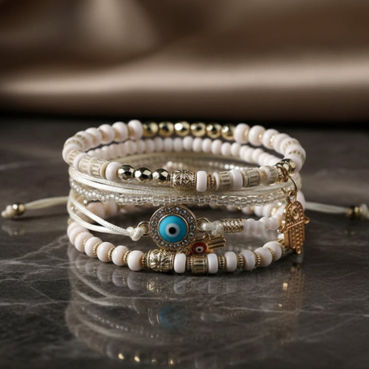 Gold hamsa bracelet bundle stacked on a model's wrist