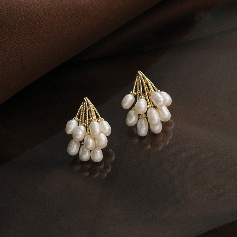 Pearl rain earrings photographed hanging against a plain backdrop
