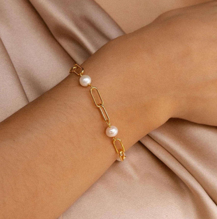 Close-up of pearls linked along the gold-tone chain