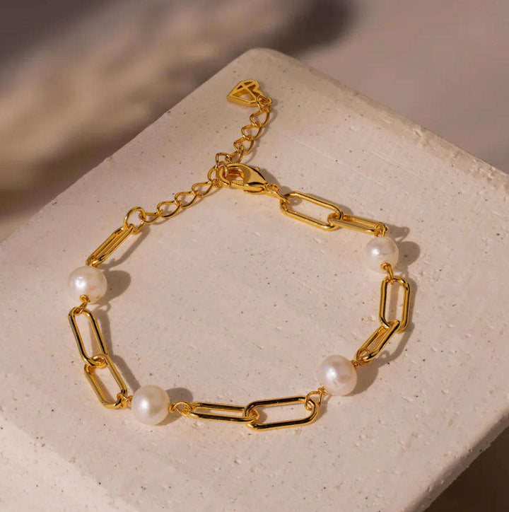 Timeless pearl chain bracelet coiled on a flat surface