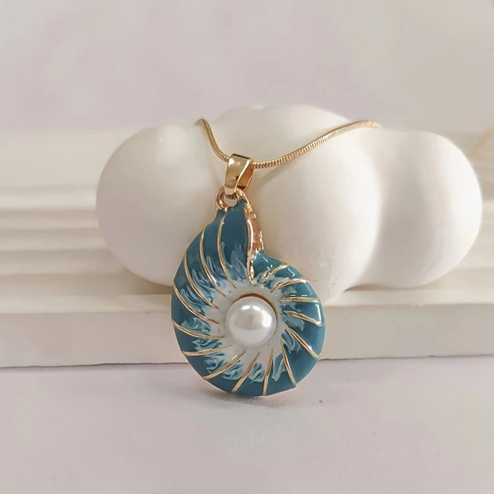 Seashell pearl pendant necklace laid flat on a plain background