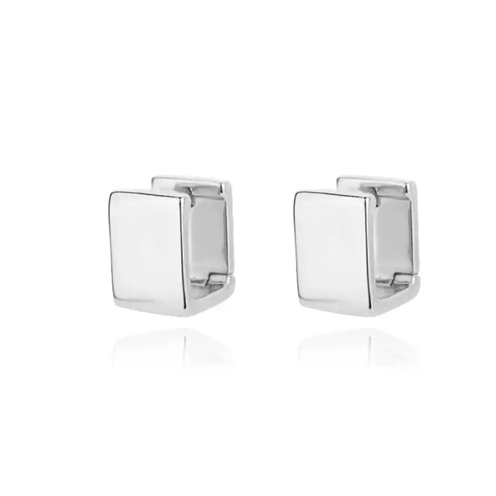 Earrings laid flat on a neutral background