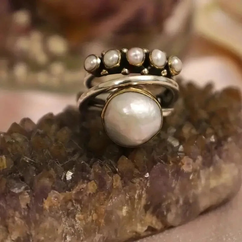 Layered pearl rings set shown stacked on a finger