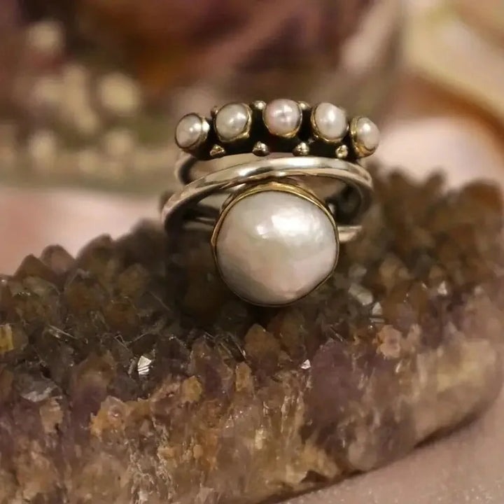 Layered pearl rings set shown stacked on a finger