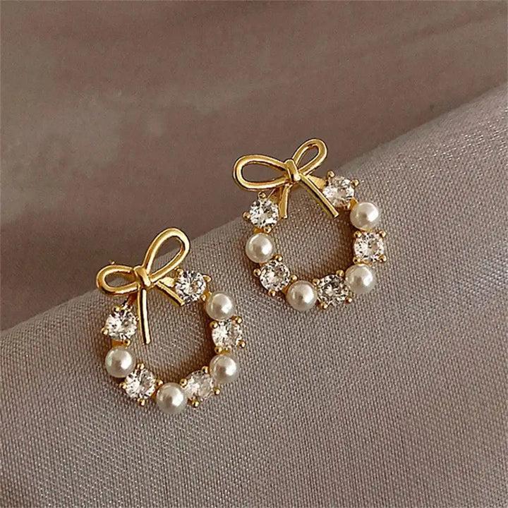 Main shot of the bow and pearl circle stud earrings
