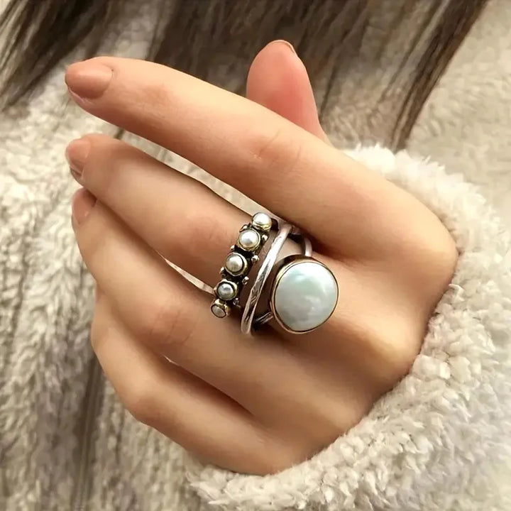 Layered pearl rings set arranged together on a white background
