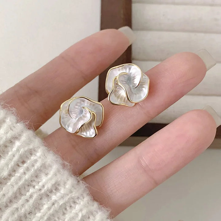 Pearl flower earrings styled next to a small gift box
