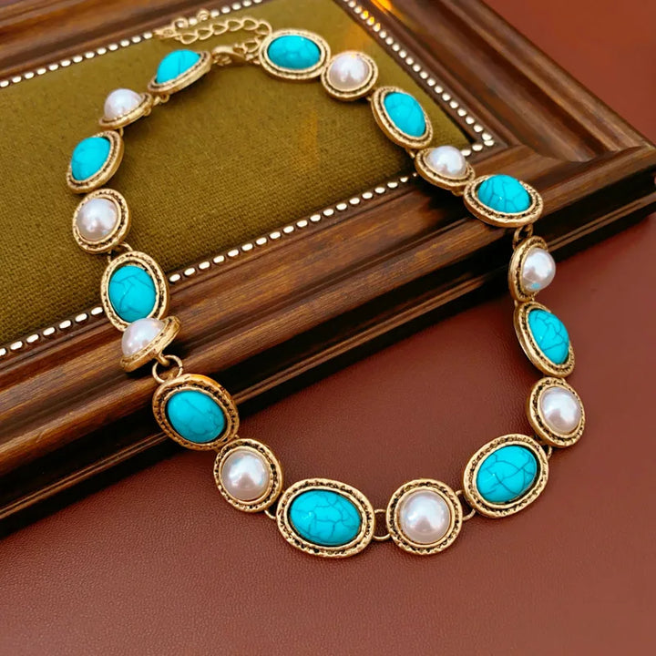 Turquoise pearl earrings shown beside the matching necklace