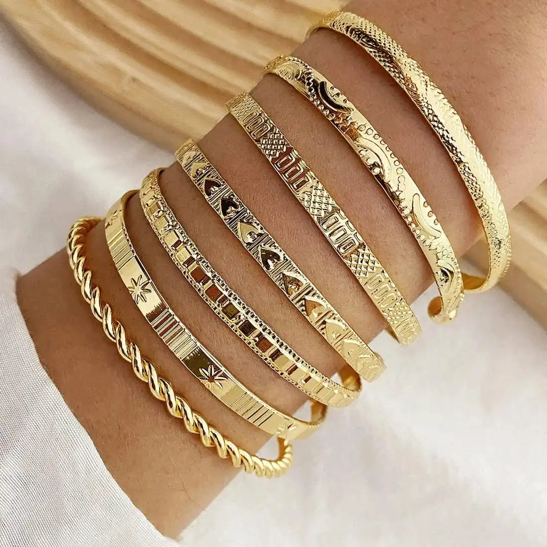 Main shot of the seven-piece gold open bangle set