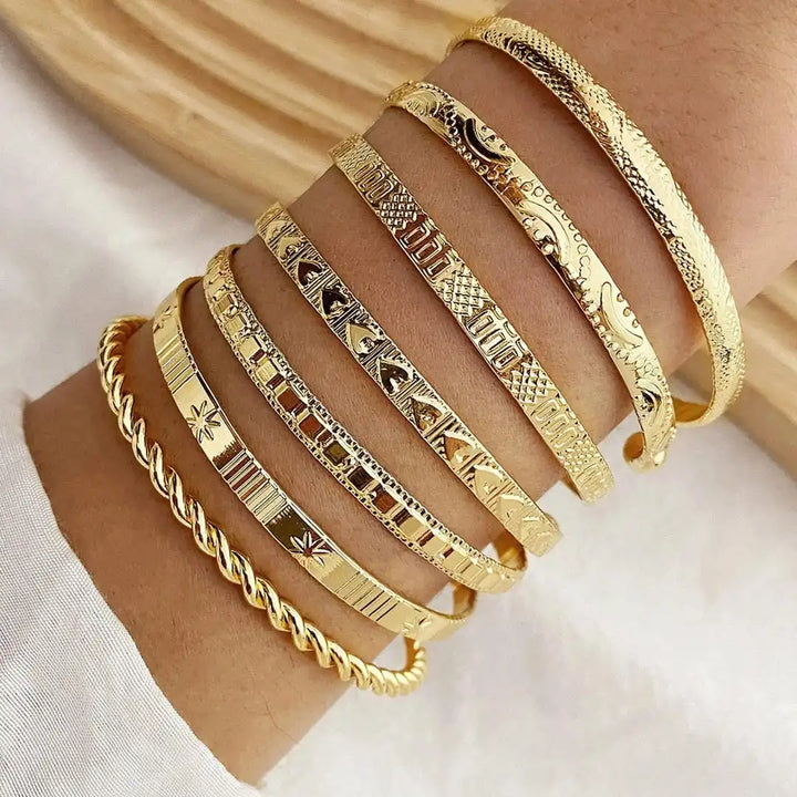 Main shot of the seven-piece gold open bangle set