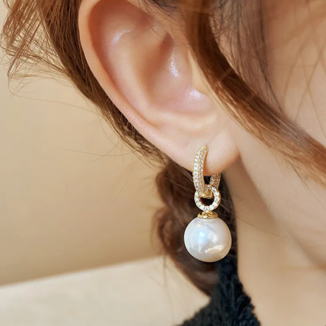 Close-up detail of the sparkling accent on the pearl earrings