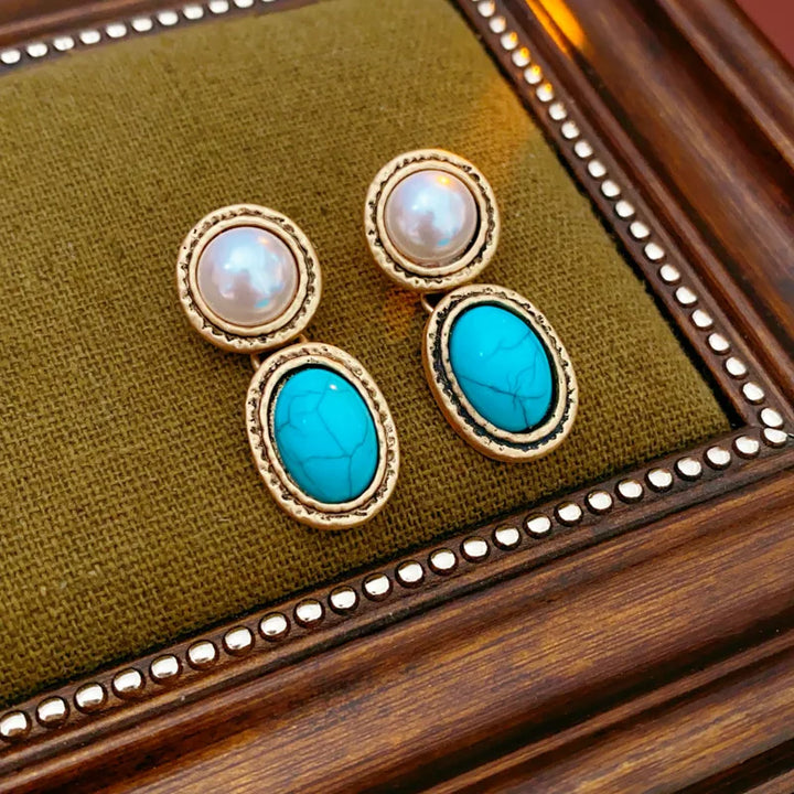 Turquoise pearl jewellery set styled flat on a neutral fabric backdrop