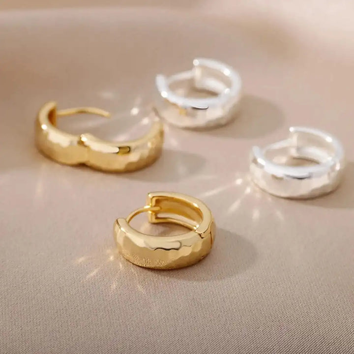 Earrings laid flat on a neutral background