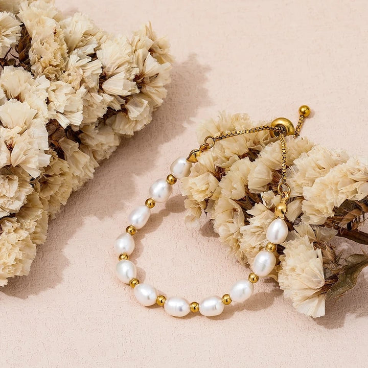 Pearl and gold bracelet worn on a model's wrist with other jewellery