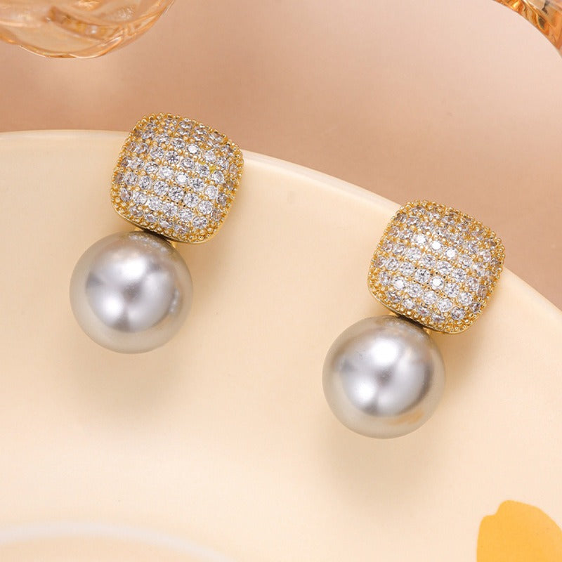 Luxe statement pearl earrings photographed on a plain backdrop