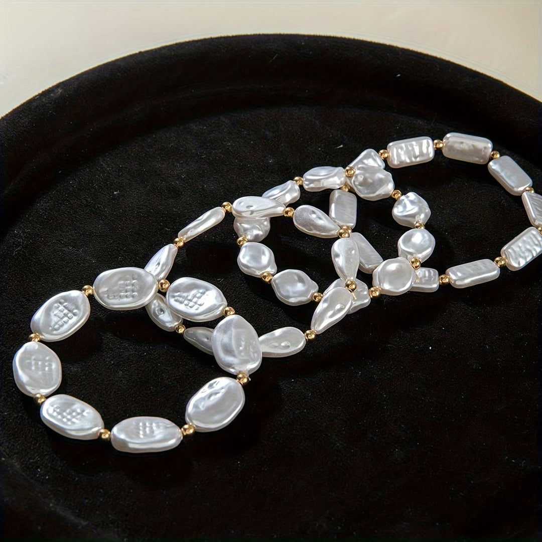 All four pearl bracelets stacked on a model's wrist
