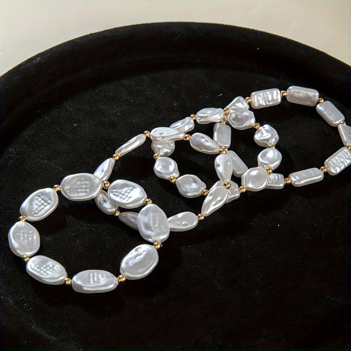 All four pearl bracelets stacked on a model's wrist