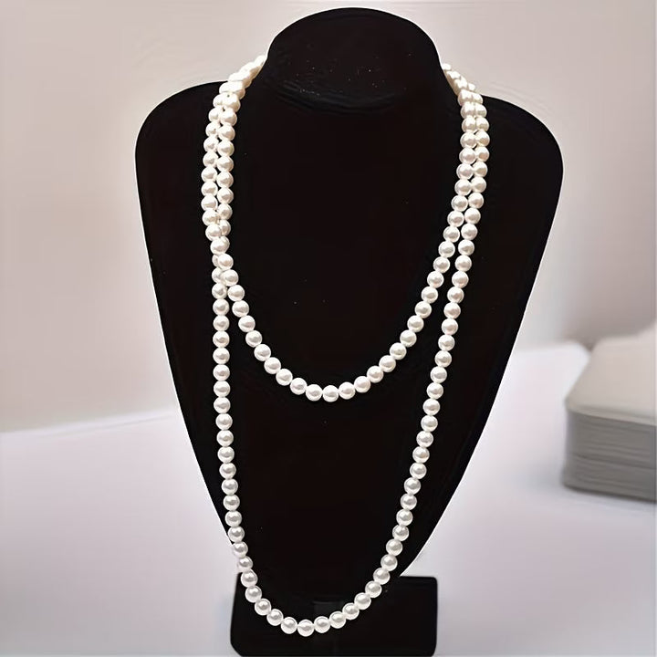 Double pearl necklace laid flat on a white background