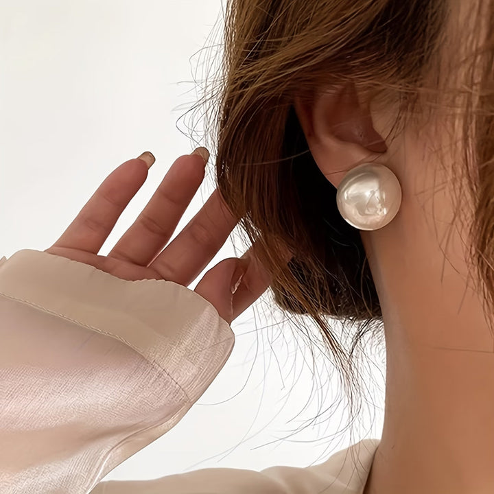 Statement pearl stud earrings shown on a white background