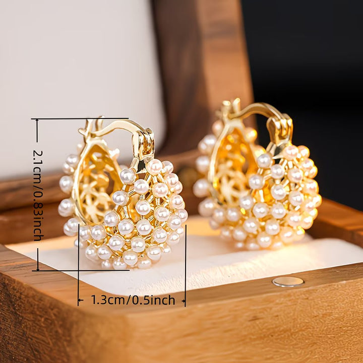 Chunky pearl hoop earrings worn on a model's ear