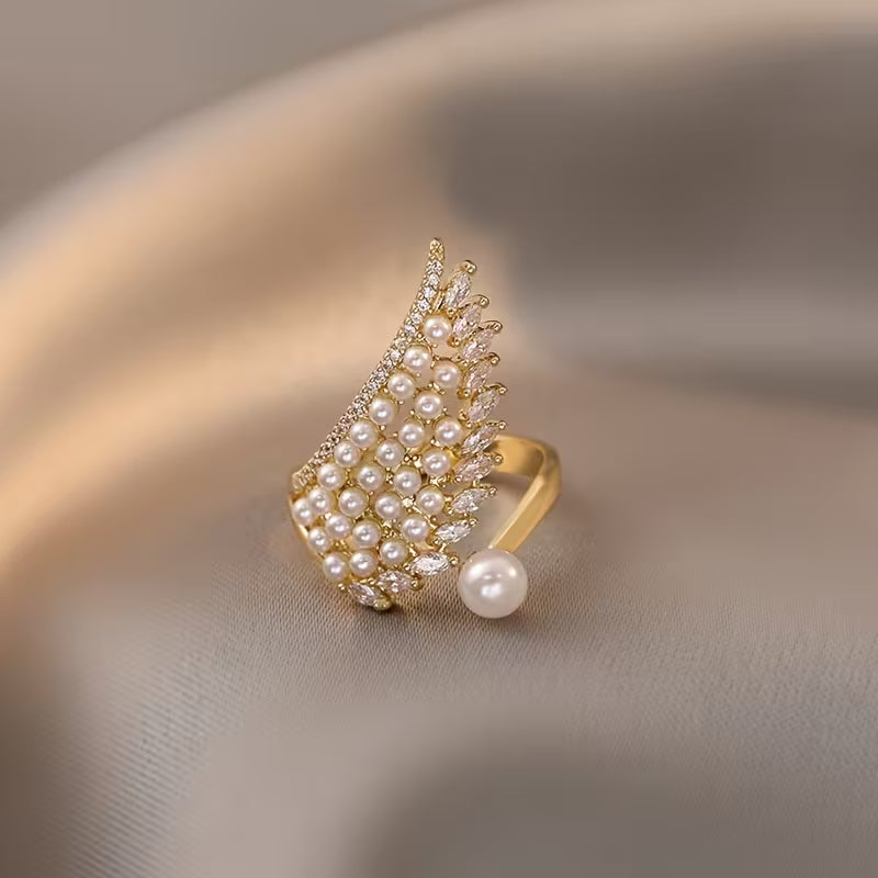 Angelic pearl wing ring shown from the front on a plain background