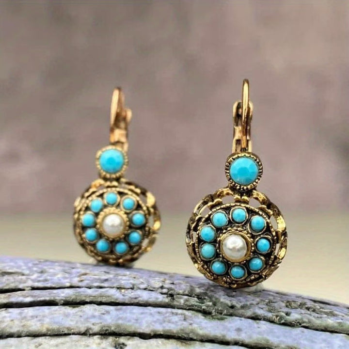 Earrings laid flat on a neutral background