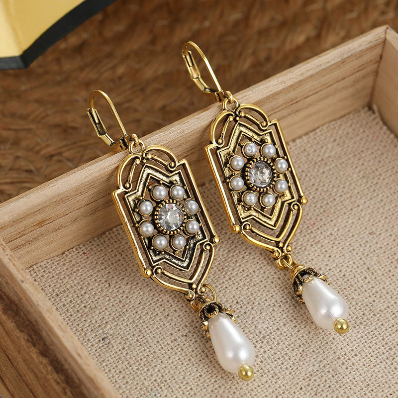 Vintage golden inlaid pearl earrings shown on a white background