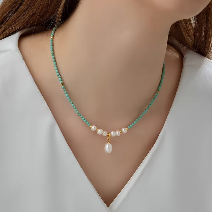 Minimal turquoise and pearl necklace laid flat on a white background