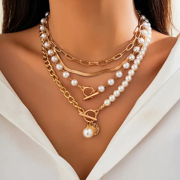 Layered pearl necklace set laid flat against a soft neutral background