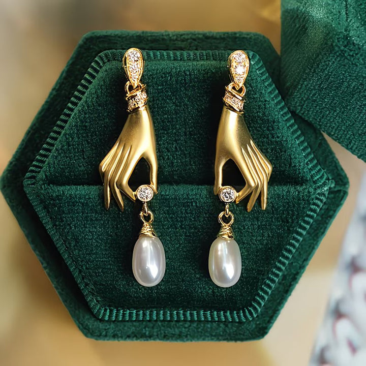 Close-up of the sculpted hand charm holding a pearl