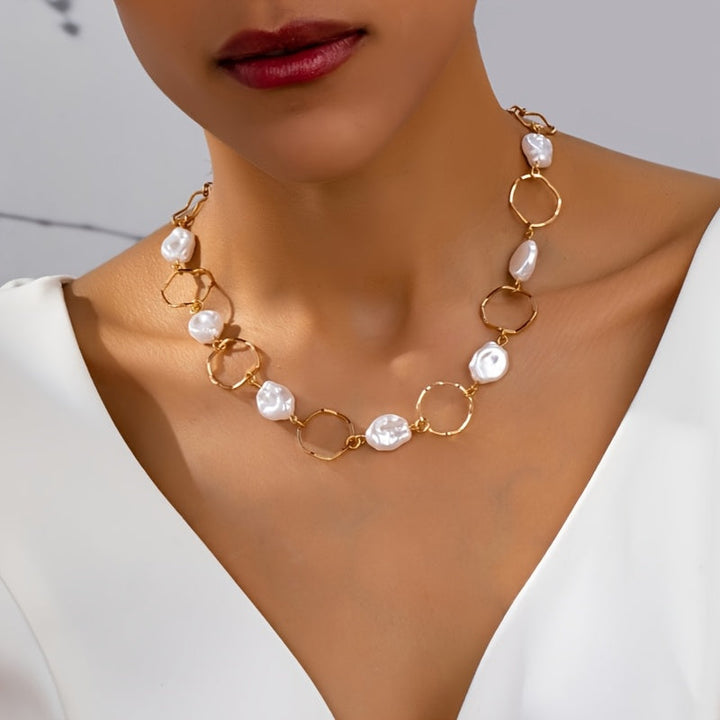 Vintage baroque pearl link necklace laid flat on a white background