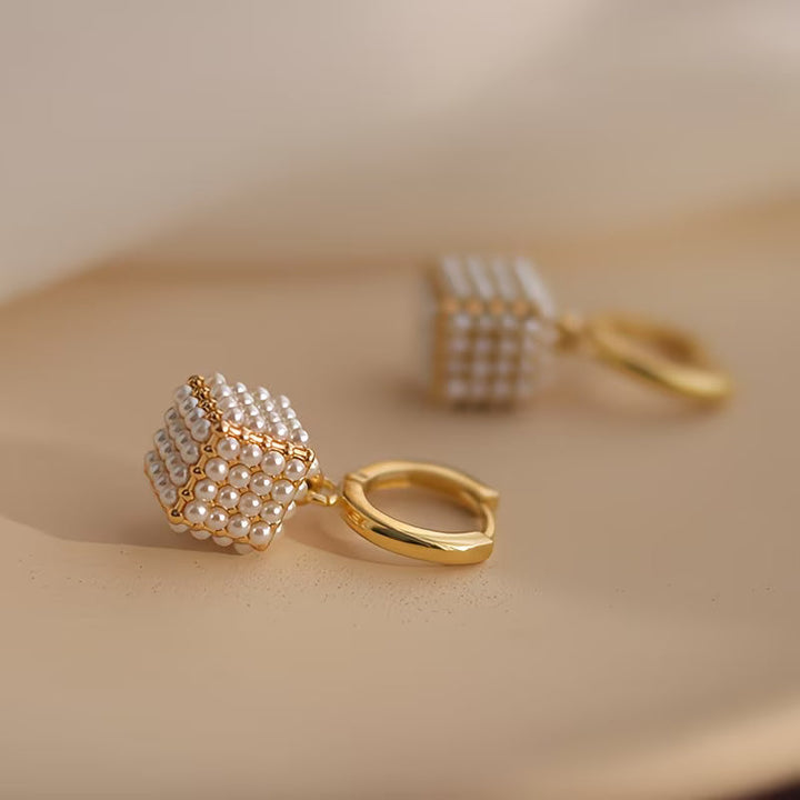 Pearl cube earrings displayed on a plain background