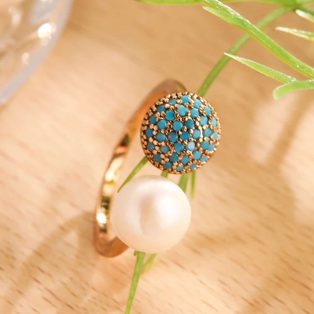 Close-up of the turquoise cabochon set beside the pearl