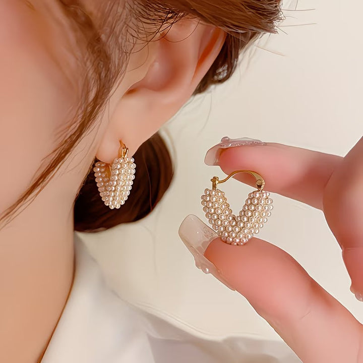 V-shaped pearl earrings photographed from a side angle