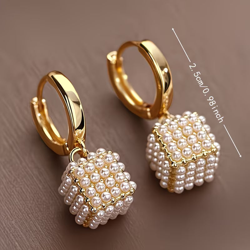 Pearl cube earrings photographed from a side angle