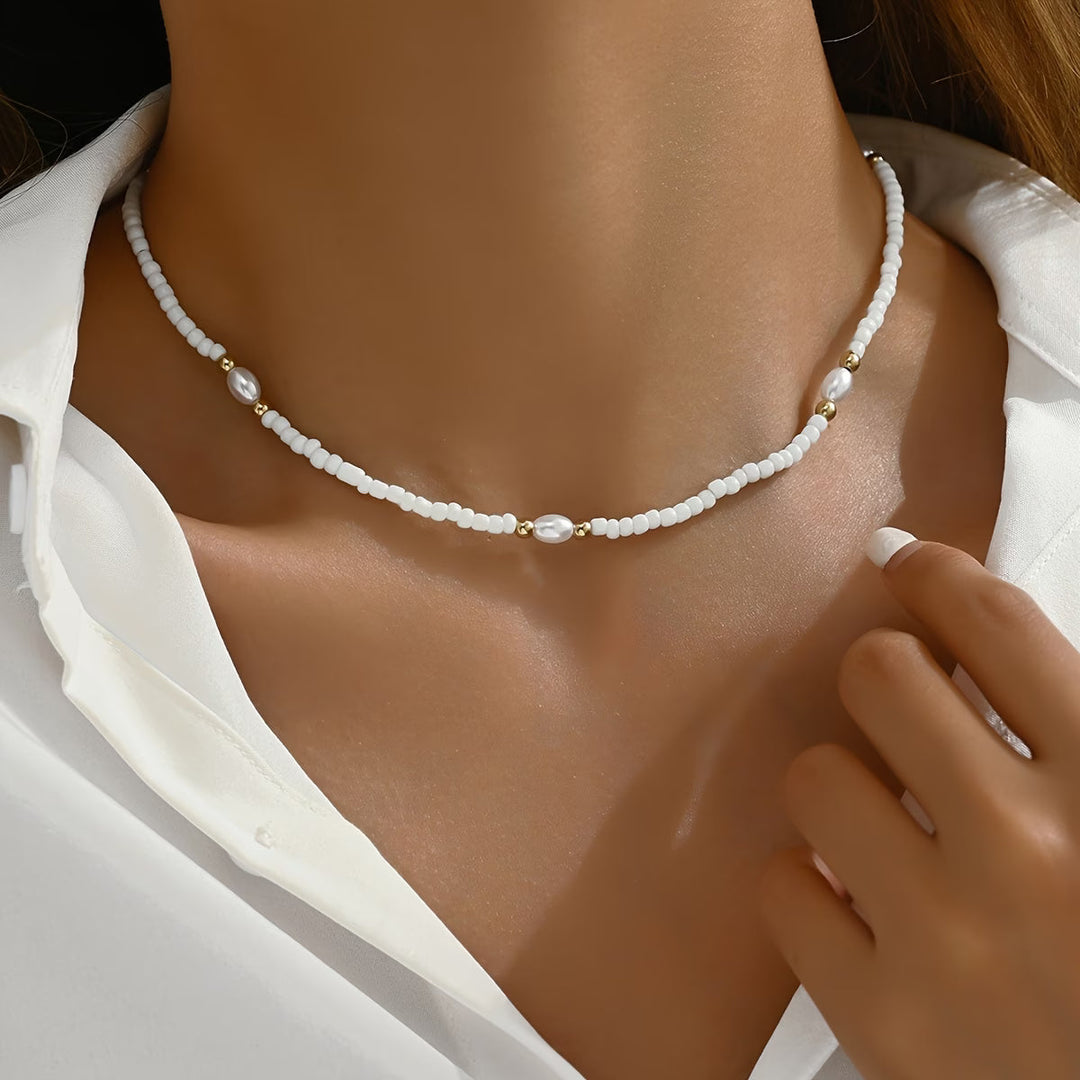 Dainty pearl beaded necklace laid flat on a white background