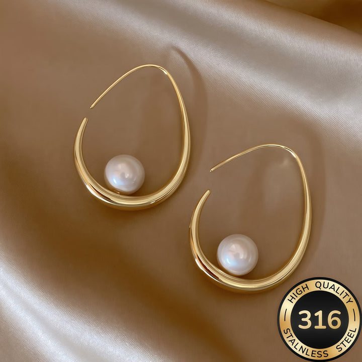Crescent pearl hoop earrings laid flat showing the curved shape