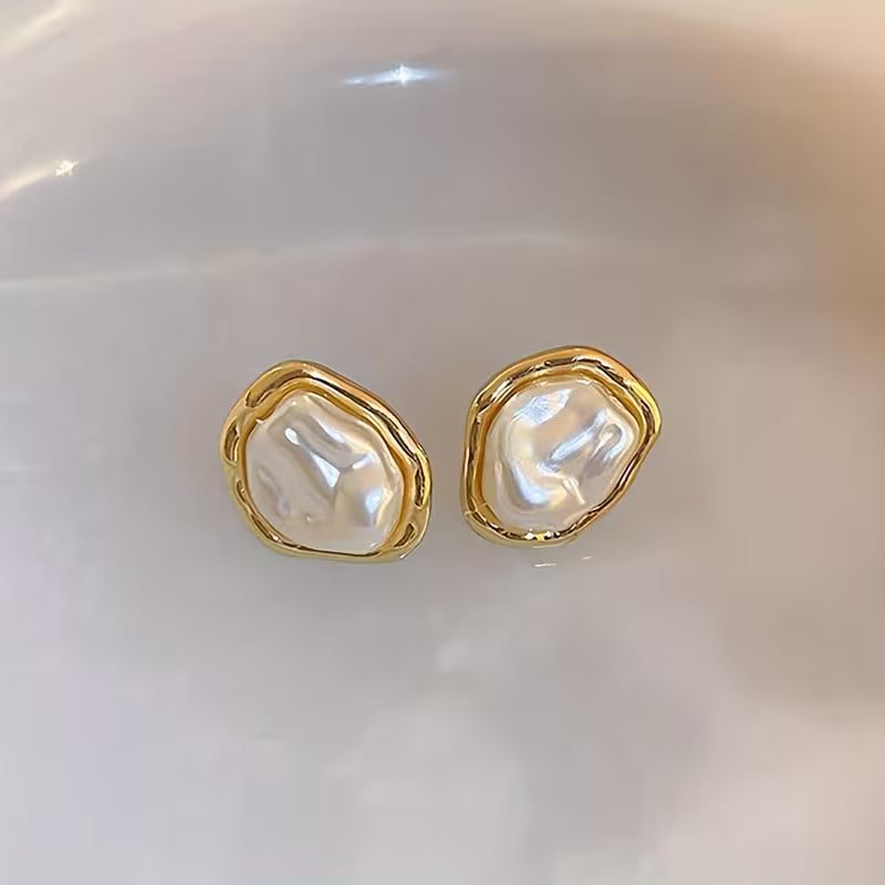 Pearl drop earrings worn in the ear to show the drape
