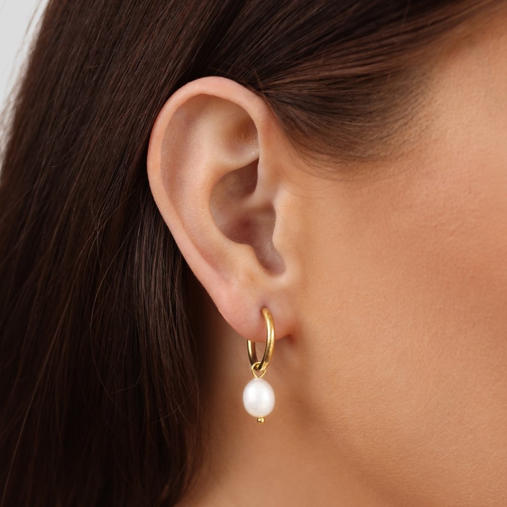Close-up of pearls set along the slim gold-tone hoop