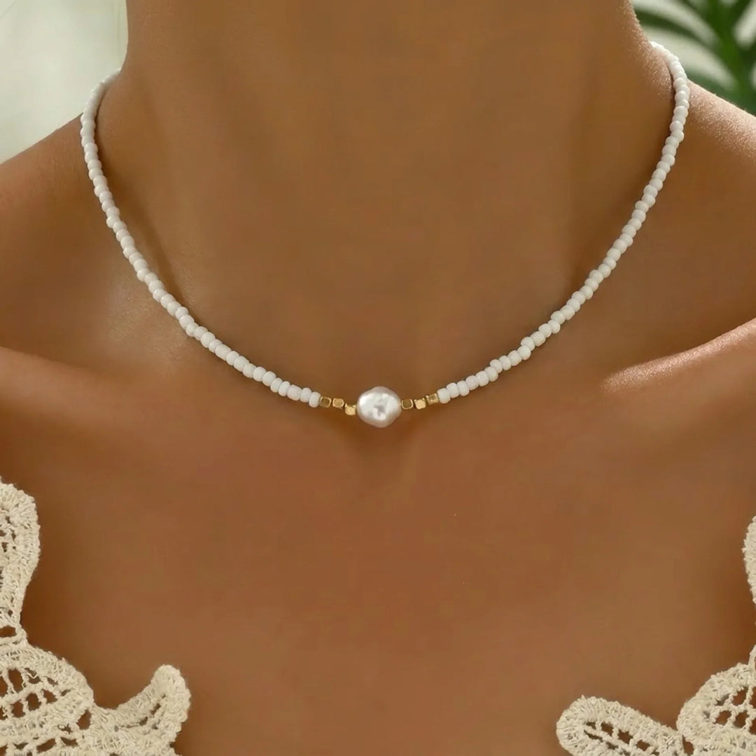 Minimal pearl necklace laid flat on a white background