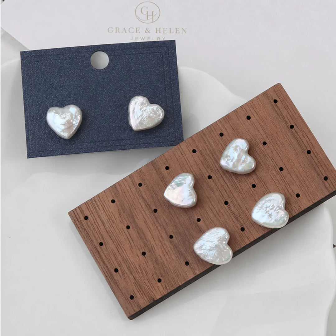 Pearl heart earrings worn in the ear to show the drop length