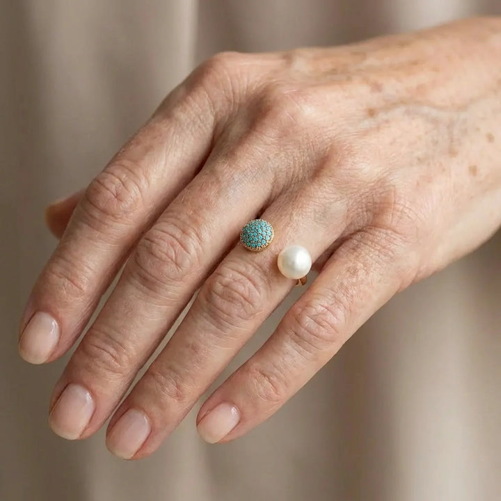 Model wearing the pearl and turquoise ring on one finger