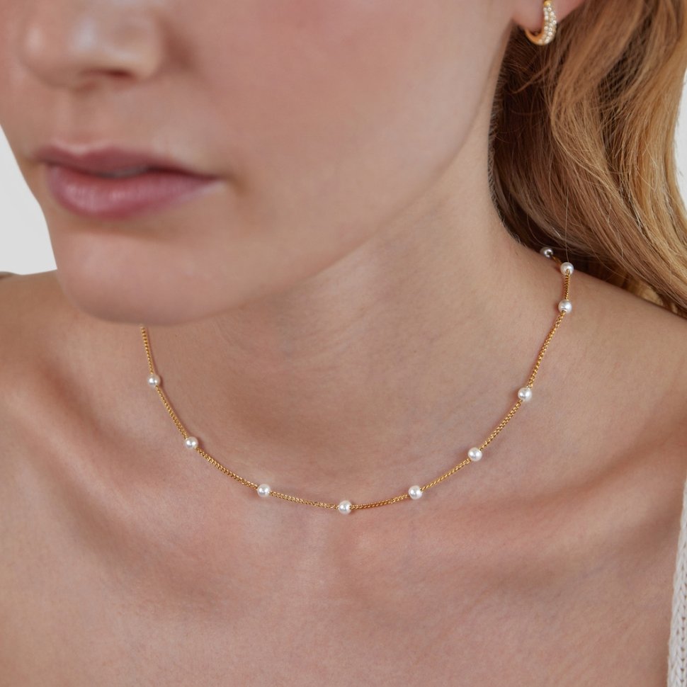 Close-up of the single pearl pendant on the gold chain