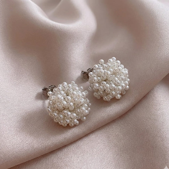 Classic inlaid pearl earrings shown on a white background
